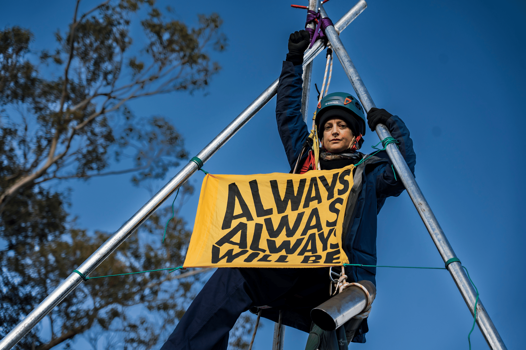 A protester suspends themselves atop a tripod on Punt Road Bridge in solidarity with Gunditjmara People opposed to seismic blasting